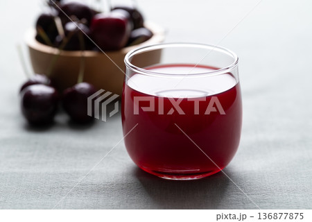 Glass of cherry juice and fresh cherries on a cotton fabric background, Healthy drink Glass of cherry juice and fresh cherries on a cotton fabric background, Healthy drink 136877875
