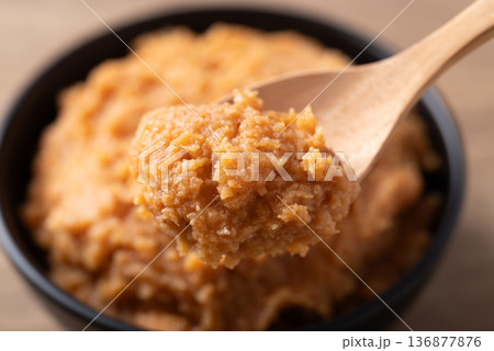 Scooping traditional Japanese miso paste from a black bowl with a wooden spoon Scooping traditional Japanese miso paste from a black bowl with a wooden spoon 136877876