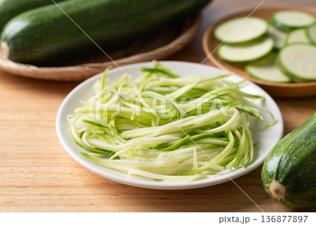 Fresh zucchini noodles (zoodles) in a white plate, prepared for healthy cooking Fresh zucchini noodles (zoodles) in a white plate, prepared for healthy cooking 136877897