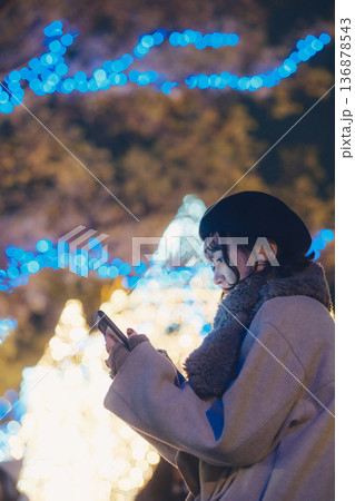 イルミネーションの前でスマートフォンを見る女性 イルミネーションの前でスマートフォンを見る女性 136878543