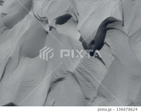 Abstract snow drifts and textured winter patterns with deep shadows and wind-sculpted shapes 136878624
