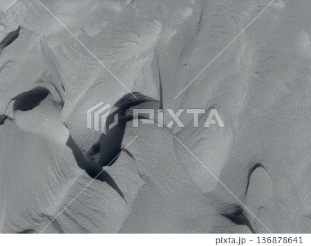Wind-sculpted snow texture with soft shadows and abstract winter patterns on alpine slope 136878641