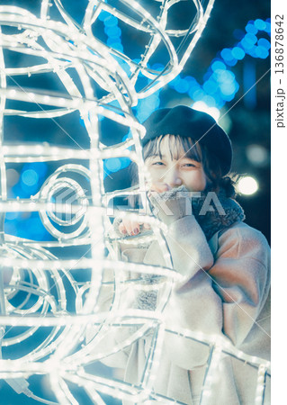 イルミネーションの前で佇む30代女性 136878642