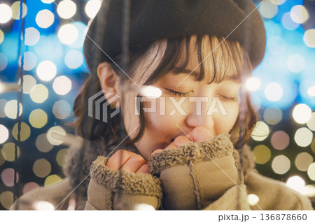 イルミネーションの前で佇む30代女性 136878660