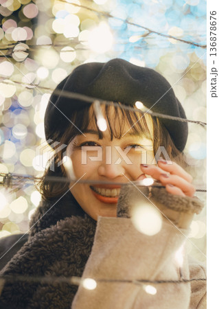 イルミネーションの前で佇む30代女性 136878676