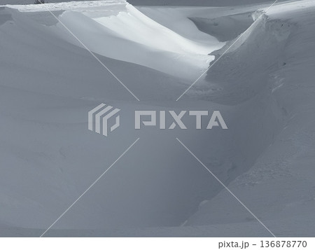 Deep snowdrift and carved snow field with soft light creating an abstract winter landscape of textures Deep snowdrift and carved snow field with soft light creating an abstract winter landscape of textures 136878770