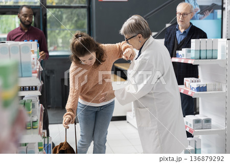 Caucasian adult woman appears dizzy while consulting senior female pharmacist at local drugstore. Medical professional offers assistance highlighting safety, wellbeing and dependable customer care. Caucasian adult woman appears dizzy while consulting senior female pharmacist at local drugstore. Medical professional offers assistance highlighting safety, wellbeing and dependable customer care. 136879292