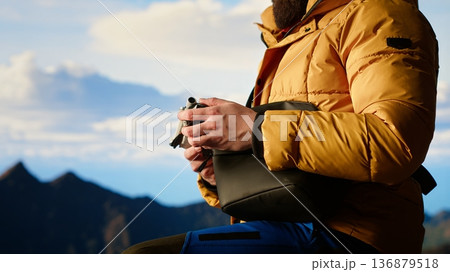 Photographer recording professional content with his drone on a mountain top, hiking in wilderness and capturing scenic landscape video. Aerial photography of wild nature. Camera B. Photographer recording professional content with his drone on a mountain top, hiking in wilderness and capturing scenic landscape video. Aerial photography of wild nature. Camera B. 136879518