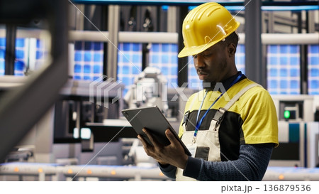 Smart factory specialist testing automated systems, monitoring operational integrity. Industry 4.0 plant technician inspecting equipment to identify and repair damages, camera B Smart factory specialist testing automated systems, monitoring operational integrity. Industry 4.0 plant technician inspecting equipment to identify and repair damages, camera B 136879536