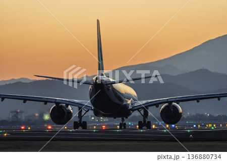 夕暮れの仙台空港　夕日と離陸中の飛行機　宮城県名取市 136880734