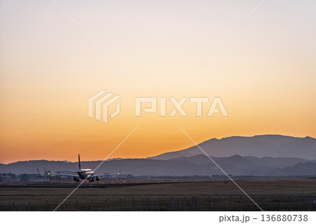夕暮れの仙台空港　夕日と離陸中の飛行機　宮城県名取市 136880738