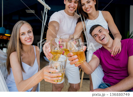 Cheerful friends in the pub. Drinking beer, talking, having fun. Cheerful friends in the pub. Drinking beer, talking, having fun. 136880749