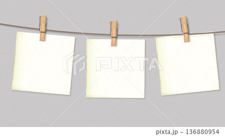 Old blank square notepapers hanging on the rope by wooden clothespins with cement wall background 136880954