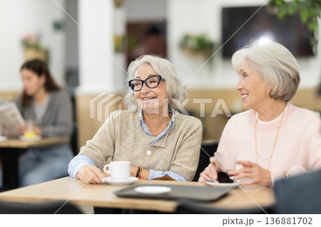 Elderly women sitting in a coffee shop and chatting 136881702