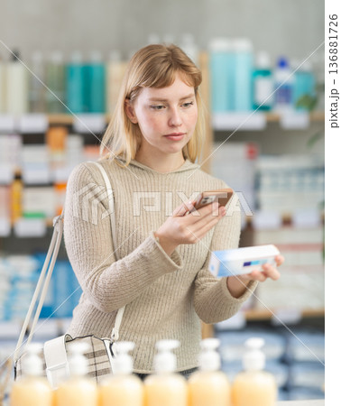 woman scans a package of ointment on her phone 136881726