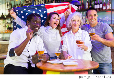 Emotional multiracial american spots supporters with flag of USA happy about victory in championship 136881983