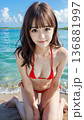 夏空のビーチでビキニの水着を着た笑顔の若い女性 136881997