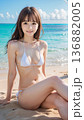 夏空のビーチでビキニの水着を着た笑顔の若い女性 136882005