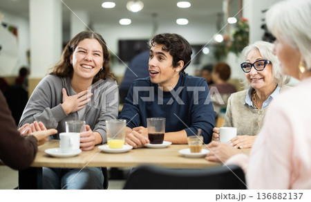 older generation of the family communicates with their grandchildren in a cafe older generation of the family communicates with their grandchildren in a cafe 136882137