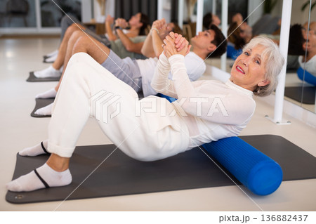 Elderly woman doing pilates with roller Elderly woman doing pilates with roller 136882437