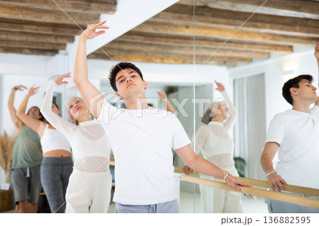 Diligent young man doing choreography at ballet barre Diligent young man doing choreography at ballet barre 136882595