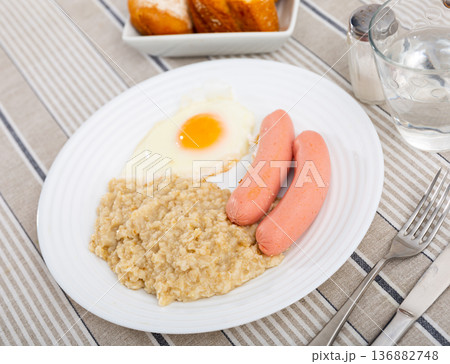 Continental breakfast for one person - portion of oatmeal, fried egg and sausage Continental breakfast for one person - portion of oatmeal, fried egg and sausage 136882748