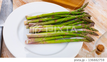 Green raw asparagus on plate prepared for cooking 136882759