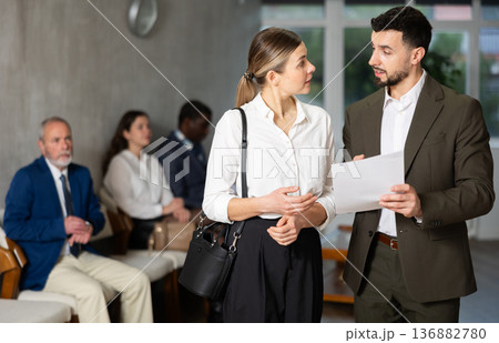 Young businessman with documents talks to female job seeker 136882780
