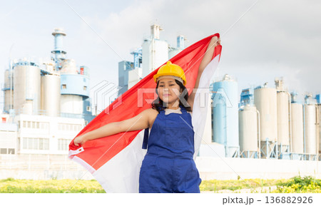 Happy young woman with helmet holding big flag of Indonesia Happy young woman with helmet holding big flag of Indonesia 136882926