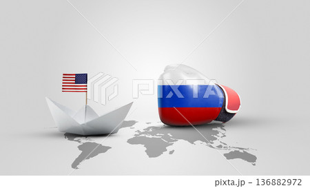 A symbolic conceptual image representing the tension between the USA and Russia, featuring a paper boat with an American flag and a Russian flag boxing glove on a world map background 136882972