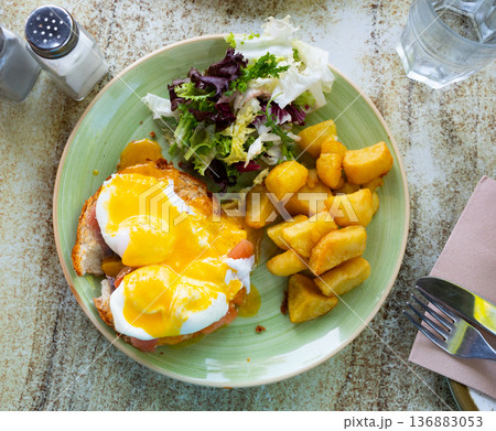 Portion of eggs benedict toast with salmon and potatoes closeup Portion of eggs benedict toast with salmon and potatoes closeup 136883053