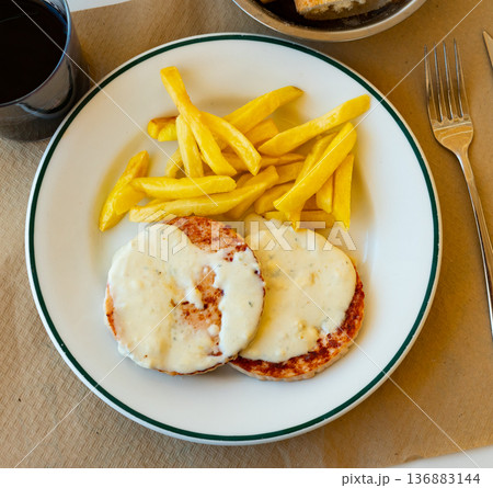 Roasted turkey breast steaks with Roquefort cheese sauce served with fried potato Roasted turkey breast steaks with Roquefort cheese sauce served with fried potato 136883144