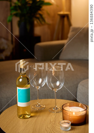 Bottle of white wine with two glasses and candles at home Bottle of white wine with two glasses and candles at home 136884390