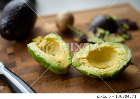 Halved Avocado with Peel and Pit on Wooden Cutting Board Halved Avocado with Peel and Pit on Wooden Cutting Board 136884571