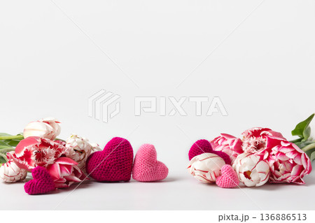Women's day banner. 8 march holiday background with pink tulips and knitted hearts. Background for website, poster, brochures, promotional materials Women's day banner. 8 march holiday background with pink tulips and knitted hearts. Background for website, poster, brochures, promotional materials 136886513