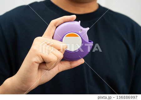 Asthma and chronic obstructive pulmonary disease COPD, Asian young man using metered dose inhaler MDI. Asthma and chronic obstructive pulmonary disease COPD, Asian young man using metered dose inhaler MDI. 136886997