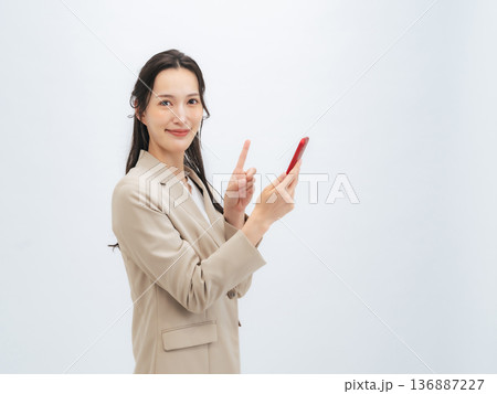 笑顔でスマホを使う女性ビジネスパーソン 136887227