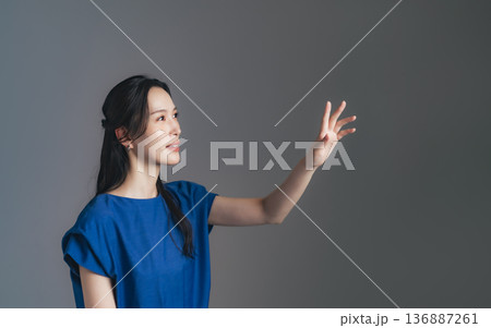 空中に手をかざす女性 136887261