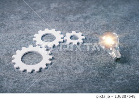 Data driven business marketing strategy promotes innovation, analytics process and market decision making concept shown with glowing light bulb and white gears on gray surface 136887649