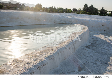 Pamukkales Stunning Travertine Terraces Reflecting Sunlight and Surrounded by Lush Greenery Provide an Enchanting Sight in Turkeys Natural Wonderland 136889869