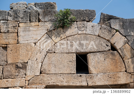 Explore Ancient Architectural Remnants at Pamukkale, Showcasing Unique Stone Formations and Historical Significance Under a Vibrant Blue Sky 136889902