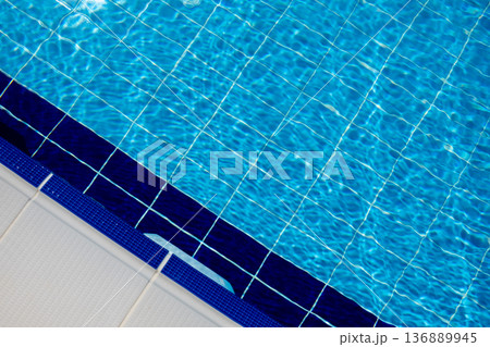 Clear Blue Water in a Swimming Pool With Tiled Edges on a Sunny Day in a Residential Area Clear Blue Water in a Swimming Pool With Tiled Edges on a Sunny Day in a Residential Area 136889945