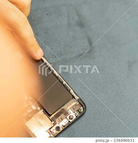 Expert Repair Technician Works on Smartphone Battery Replacement With Precision and Skill in a Clean Workspace During Daytime Expert Repair Technician Works on Smartphone Battery Replacement With Precision and Skill in a Clean Workspace During Daytime 136890631