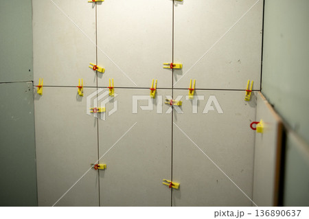 Drywall Installation Process in a Home Interior With Colorful Clips Used for Securing Panels During Alignment and Setup 136890637