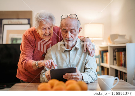 Senior coule working with tablet, making reservation or shopping online. Senior coule working with tablet, making reservation or shopping online. 136891377
