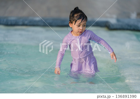 preschool child girl playing and swimming in pool preschool child girl playing and swimming in pool 136891390