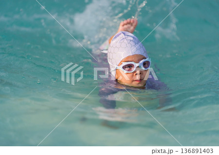 preschool child girl playing and swimming in pool preschool child girl playing and swimming in pool 136891403