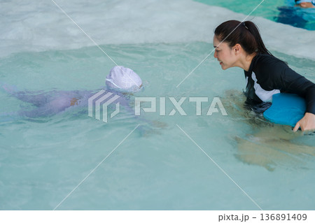 preschool child girl learning to diving with her mother in swimming pool 136891409