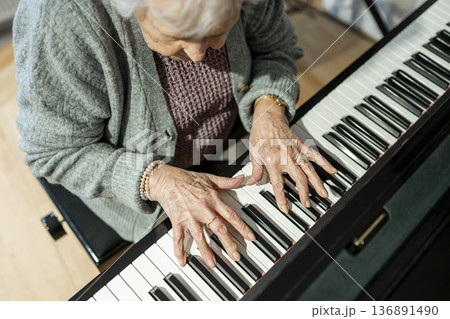 Senior woman playing piano in retirement. 136891490