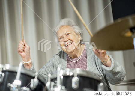Senior woman enjoying her hobby playing drums. 136891522